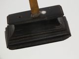 a metal object with a wooden handle on a white surface
