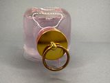 a pink bottle with a gold ring on it