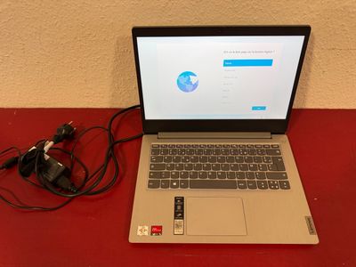 a laptop computer sitting on a red table with a charger