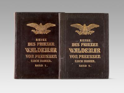 an old book with a gold eagle on the front and a black book with a gold eagle on the back