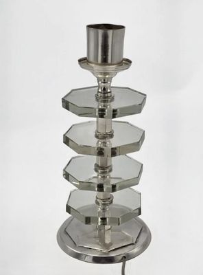 a glass candle holder with a candle on it