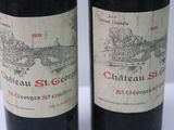 two bottles of red wine sitting next to each other on a table