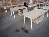 many desks and chairs in a room with a brick wall