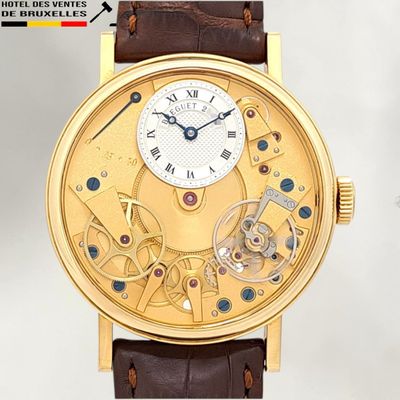 a close up of a gold watch with a brown leather strap