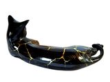 a black and gold cat figurine on a white background