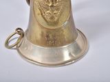 a brass bell with an eagle on it on a white surface