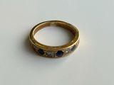 a close up of a gold ring with blue stones on it