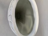 a white vase that has a hole in it