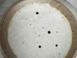 a white plate with a brown rim on a table