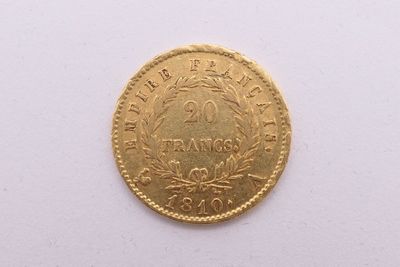 gros plan d'une pièce d'or sur une surface blanche