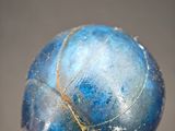 a close up of a blue glass ball on a stick
