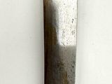 a knife with a wooden handle hanging on a wall