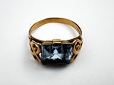 a close up of a gold ring with a blue topaz stone