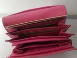 a close up of a pink purse on a white table