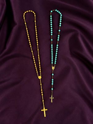 two rosary beads on a purple satin background