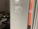 a white refrigerator in a small kitchen with a stove