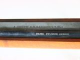 a close up of a gun on a wooden table with a white background