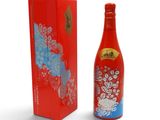 une bouteille de vin rouge à côté d'une boîte rouge