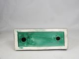 an image of a green and white plate with holes in it