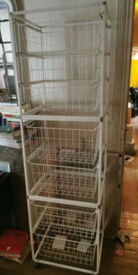 une étagère en fil métallique blanc surmontée de paniers
