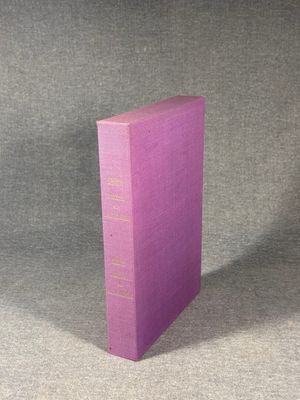 a purple book sitting on top of a table next to a gray wall