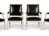 quatre chaises noires et blanches avec des assises en cuir noir, sur fond blanc