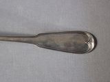 a silver spoon with a heart shaped handle sitting on a table