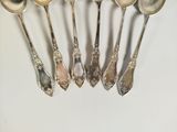five spoons that are sitting next to each other on a table