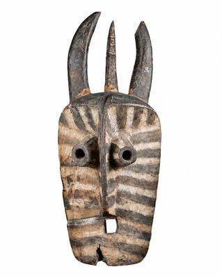 une image représentant un masque en bois muni de cornes sur fond blanc