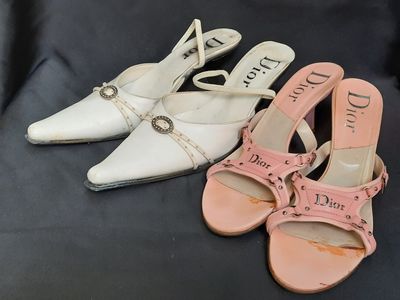 deux paires de chaussures blanches et roses posées sur une surface noire
