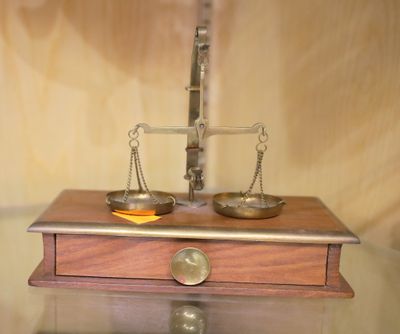 une photo d'une balance posée sur une table, sur laquelle se trouve un bol de fruits