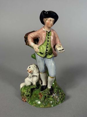 figurine représentant un homme avec un chien sur un fond vert