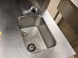 a sink in the middle of a stainless steel counter
