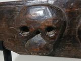 a wooden sculpture of a skull on display in a museum
