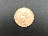 a close up of a gold coin on a black surface