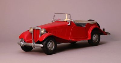 a red toy car that is sitting on a table