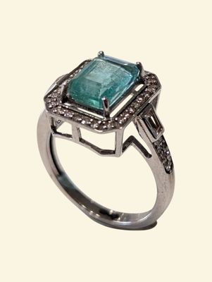 an image of a ring with a green stone surrounded by diamonds