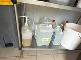 a metal shelf with several containers and buckets on it