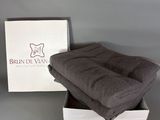 brown blanket in a white box on a table with a grey background