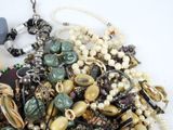 a pile of assorted beads and necklaces on a table