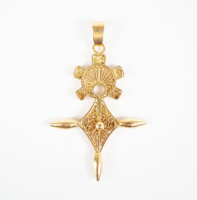 an image of a gold pendant with a cross on it
