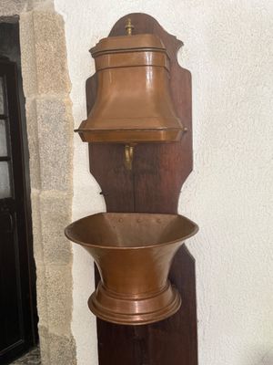 a tall wooden shelf with a metal bowl on it