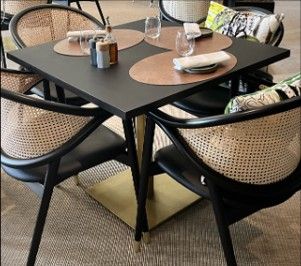 une table avec quatre chaises et une table sur laquelle sont disposés des couverts