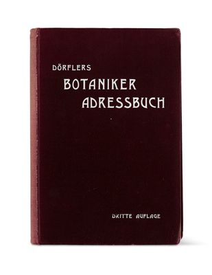 a red book sitting on top of a table next to a white wall