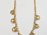 a gold necklace with hearts and leaves on a chain