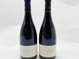 deux bouteilles de vin rouge posées sur une table blanche