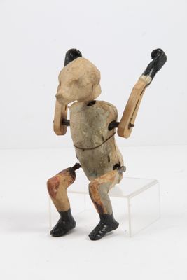 figurine en bois représentant un homme tenant une batte de baseball, posée sur un socle transparent