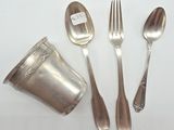 a silver spoon, fork, and a cup on a table