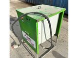 a green and white machine sitting on top of a cement floor