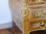 a marble top chest of drawers on a wooden floor